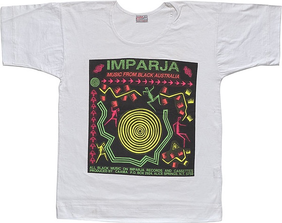 Artist: b'REDBACK GRAPHIX' | Title: b'T-shirt: Imparja.' | Date: 1985 | Technique: b'screenprint, printed in colour, from multiple stencils' Artist: b'REDBACK GRAPHIX' | Title: b'T-shirt: Imparja.' | Date: 1985 | Technique: b'screenprint, printed in colour, from multiple stencils'
